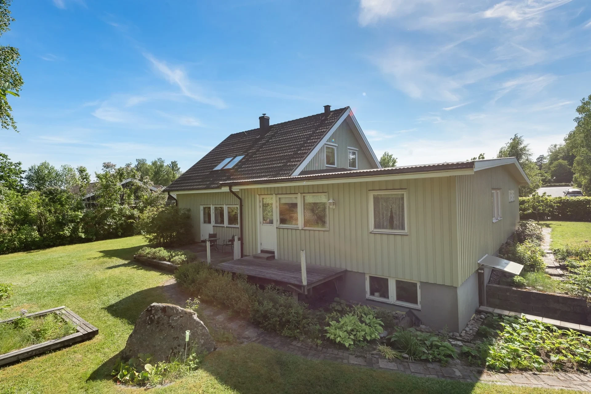Rymligt familjehus med separat bostadsdel, solceller och lummig trädgård mot naturen
