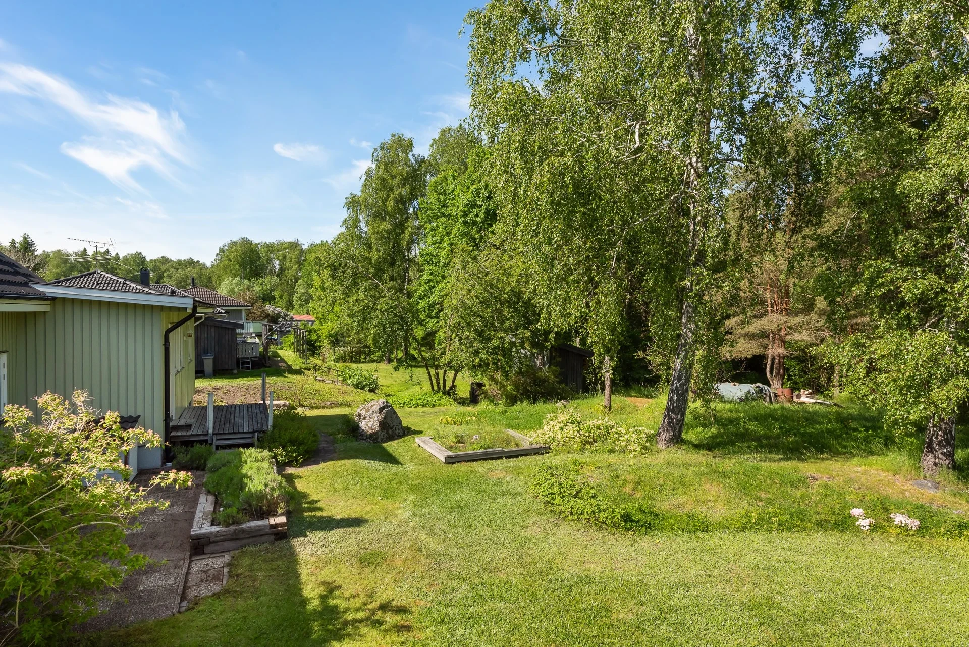 Rymligt familjehus med separat bostadsdel, solceller och lummig trädgård mot naturen